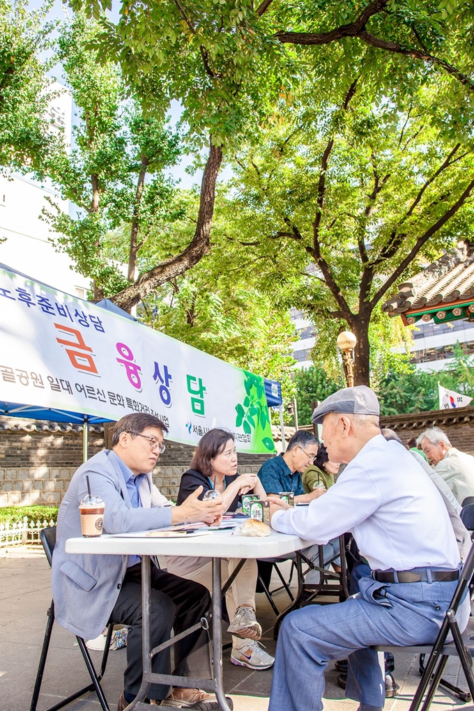 이재헌(왼쪽부터)씨와 김정신씨가 2017년 서울 탑골공원에서 어르신을 상대로 재무상담을 하고 있다. 다우리이엔씨협동조합 제공