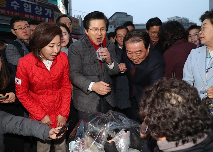 자유한국당 황교안 대표가 5일 새벽 서울 남대문시장을 방문해 시장 상인과 인사 후 상인이 파는 김밥을 사서 맛보고 있다. 연합뉴스