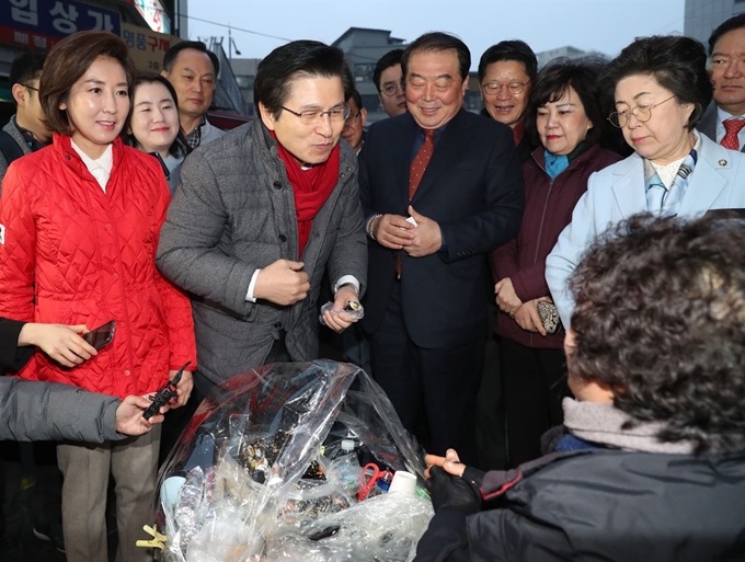 자유한국당 황교안 대표가 5일 오전 서울 남대문시장을 방문해 시장 상인과 인사 후 상인이 파는 김밥을 사서 맛보고 있다. 연합뉴스.