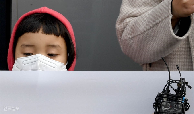 5일 서울 용산구 한국유치원총연합회(한유총) 사무실 앞에서 '정치하는 엄마들'이 검찰고발 기자회견을 하는 동안 한 아이가 이 모습을 지켜보고 있다. 서재훈 기자