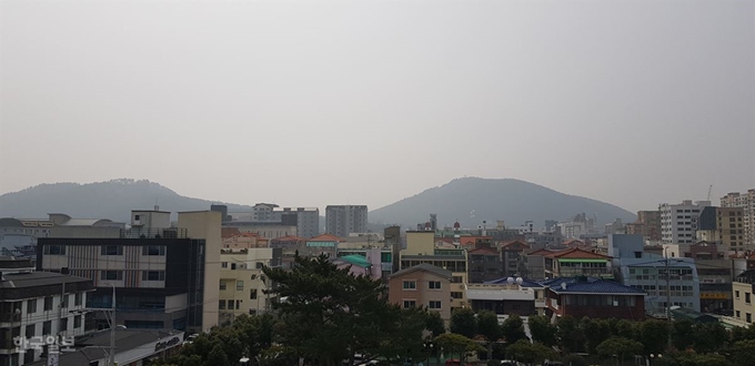 [저작권 한국일보]지난 5일 오후 제주 제주시 연동에 위치한 제주도청 옥상 위에서 바라본 전경에는 평소 민오름(사진 왼쪽)과 남조순오름(사진 오른쪽) 사이에 보이던 한라산이 미세먼지에 가려 보이지 않고 있다. 김영헌 기자.