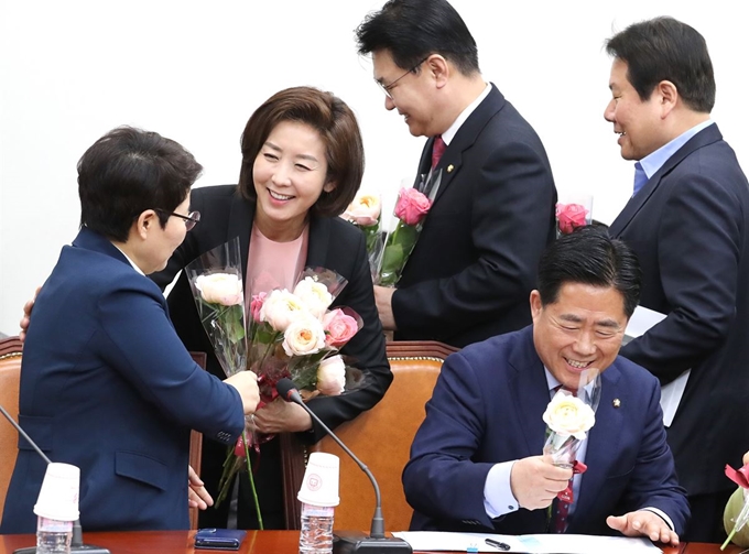 자유한국당 나경원 원내대표(왼쪽 두번째)가 8일 오전 국회에서 열린 원내대책회의에 입장하며 3·8 세계 여성의 날을 맞아 참석한 의원들에게 장미꽃을 나눠주고 있다. 연합뉴스