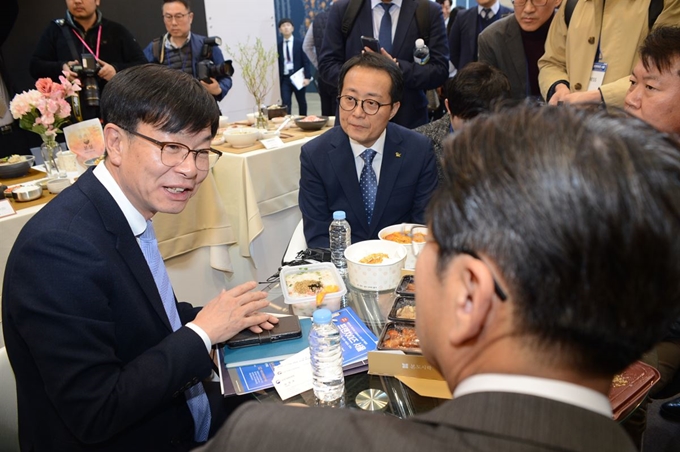 김상조(왼쪽) 공정거래위원장이 8일 서울 강남구 코엑스에서 열린 프랜차이즈 박람회 본죽 부스를 방문해 관계자들과 이야기를 나누고 있다. 공정거래위원회 제공