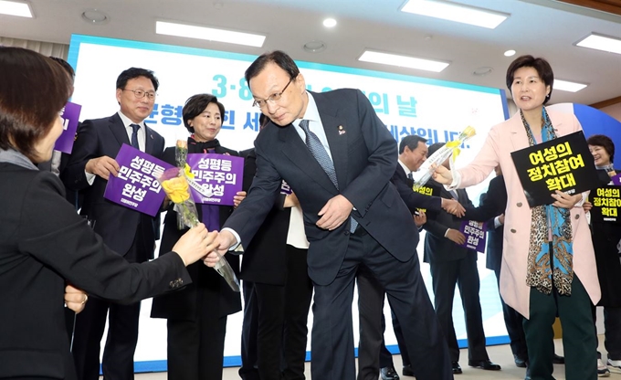 이해찬 더불어민주당 대표가 8일 오전 경기도 수원 경기도청에서 열린 '민주당-경기도 예산정책협의회'에서 세계여성의 날 기념 장미꽃을 참석자에게 전달하고 있다. 더불어민주당 제공=뉴시스