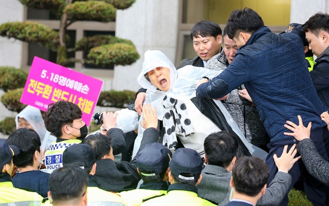 전두환 씨가 광주지법원을 나가자 한 시민이 이를 저지하려 몸을 던지고 있다. 광주=서재훈 기자