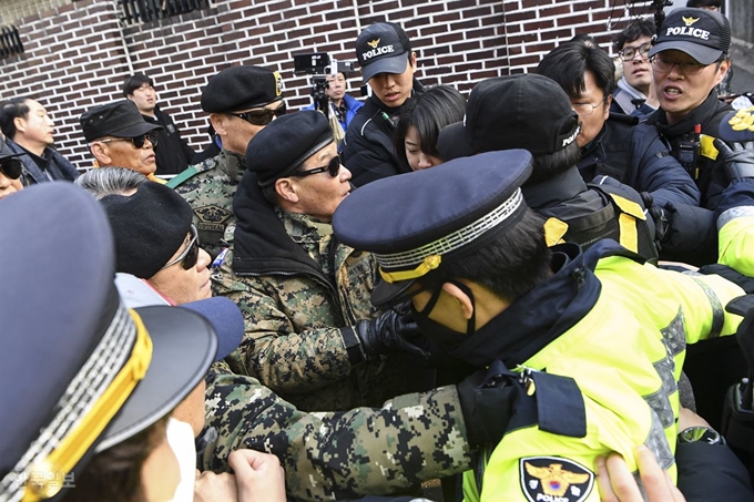 사자명예훼손 혐의로 기소된 전두환씨가 광주지법에서 열리는 재판에 출석하는 11일 전씨의 연희동 자택 앞 골목에서 보수단체 회원들이 취재진과 경찰병력을 향해 욕설을 하며 몸싸움을 걸고 있다. 이한호 기자