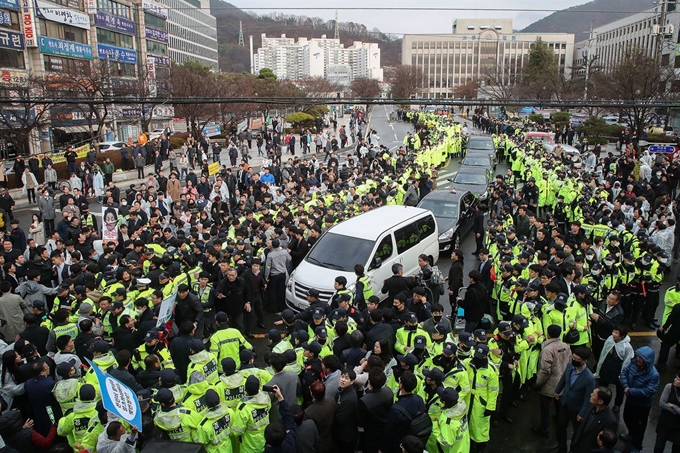 전두환 전 대통령이 5·18 민주화운동 관련 피고인으로 11일 광주지방법원에서 재판을 마치고 법원을 나서자 광주 시민들이 차량 행렬을 막아서고 있다. 연합뉴스