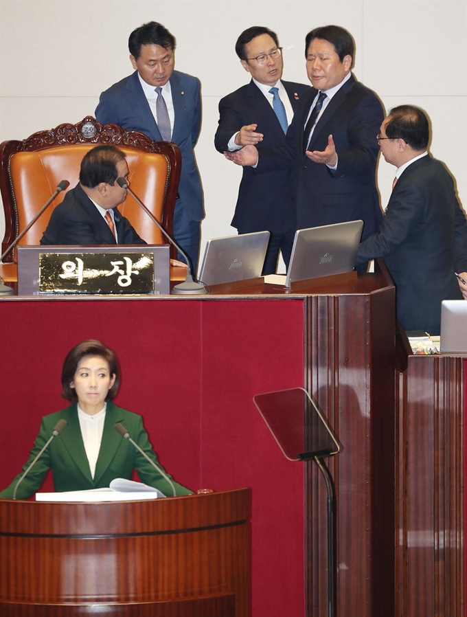 자유한국당 나경원 원내대표가 12일 오전 국회 본회의장에서 교섭단체 대표연설을 하던 중 정부가 북한의 대변인이라는 식의 발언을 하자 더불어민주당 홍영표 원내대표(뒷줄 가운데)가 국회의장석으로 나가 강하게 항의하고 있다. 연합뉴스