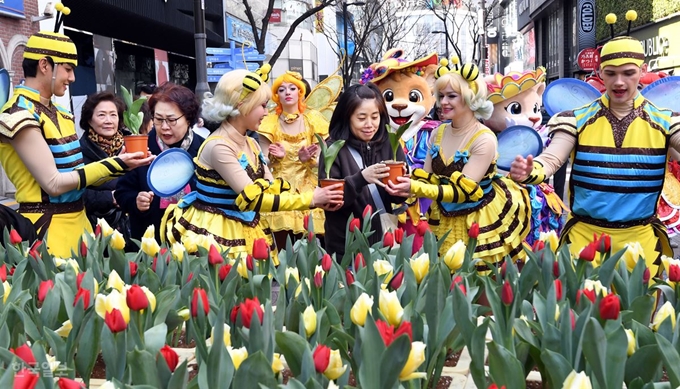 13일 서울 명동 거리에서 에버랜드 대표 캐릭터인 레니.라라와 나비.꿀벌 복장의 연기자들이 '에버랜드 튤립축제'를 홍보하며 시민들에게 튤립을 나눠주고 있다.배우한 기자