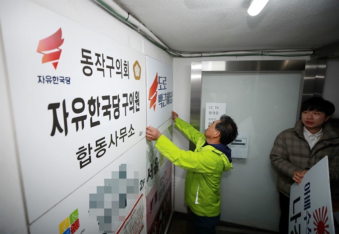 정의당, 민중당과 6.15공동선언실천 남측위원회 서울본부에 참여하고 있는 단체 회원들이 13일 서울 동작구 자유한국당 나경원 원내대표의 지역구 사무실을 찾아 전날 나 원내대표의 국회 원내교섭단체 발언을 규탄하며 사무실 현판을 바꿔다는 상징의식을 펼치고 있다.연합뉴스