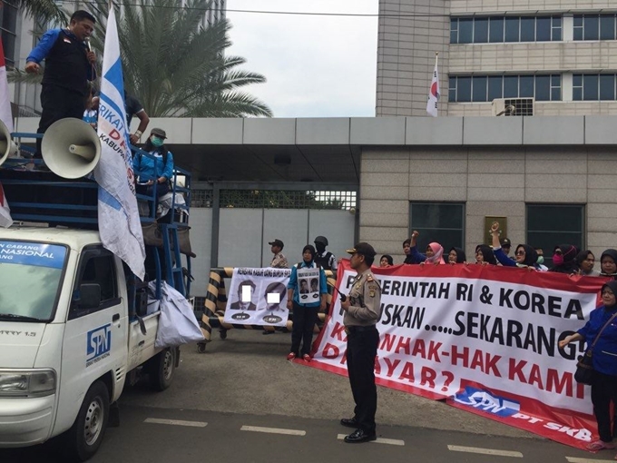 14일 인도네시아 주재 한국대사관 앞에서 ㈜에스카베(SKB) 노동자들이 ‘인도네시아와 한국 정부는 언제 내 월급을 돌려줄 것인가’라는 문구를 들고 미지급 임금 문제 해결을 촉구하는 집회를 열고 있다.