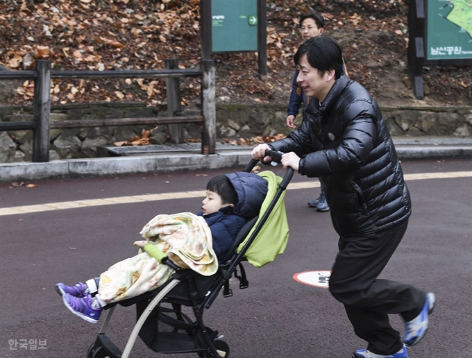 16일 남산 백범광장에서 열린 제481회 한국일보 거북이마라톤에 참가한 시민이 어린 아이를 태운 유모차를 밀며 남산길을 오르고 있다. 이한호 기자