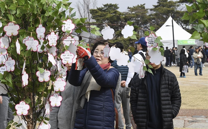 16일 남산 백범광장에서 열린 제481회 한국일보 거북이마라톤에서 한 시민이 소원을 적어 나무에 걸고 있다. 이한호 기자