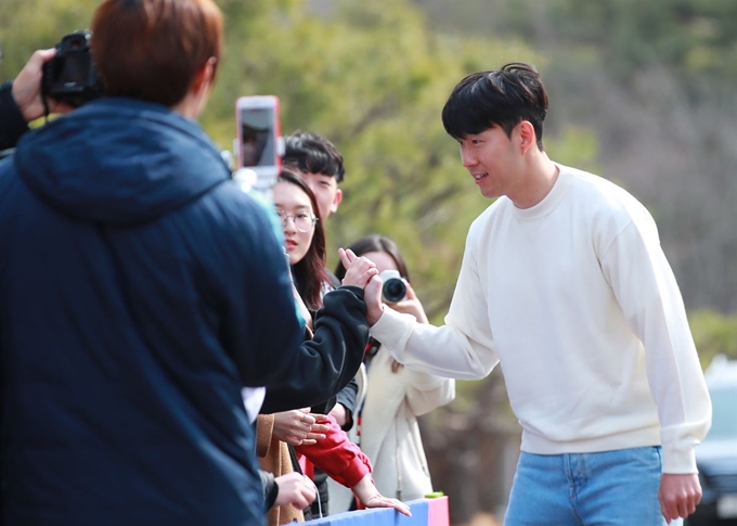 손흥민이 18일 오후 경기도 파주시 축구대표팀트레이닝센터(NFC)에서 실시된 소집 훈련에 참가하기 위해 센터로 들어가며 축구팬들과 하이파이브를 하고 있다. 연합뉴스