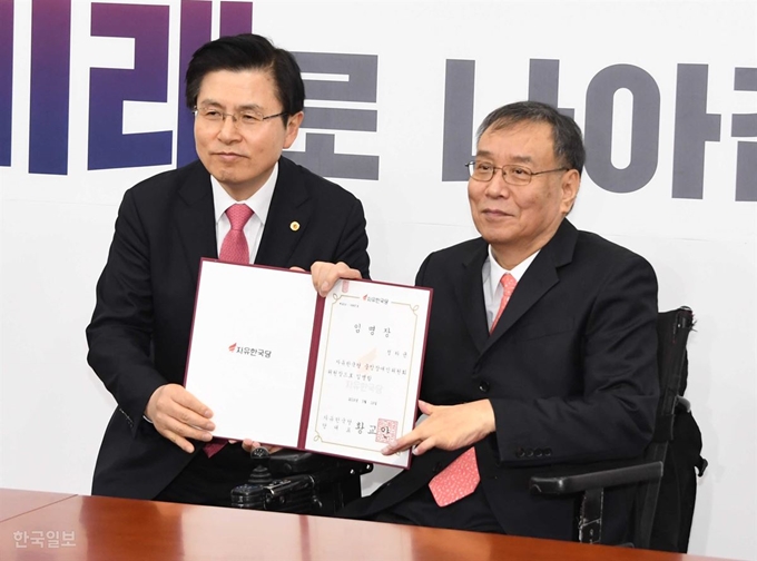 황교안 자유한국당 대표가 19일 국회에서 주요당직자 임명장 수여 중 정하균 중앙장애인위원장과의 사진촬영을 위해 몸을 낮춰 포즈를 하고 있다. 오대근기자