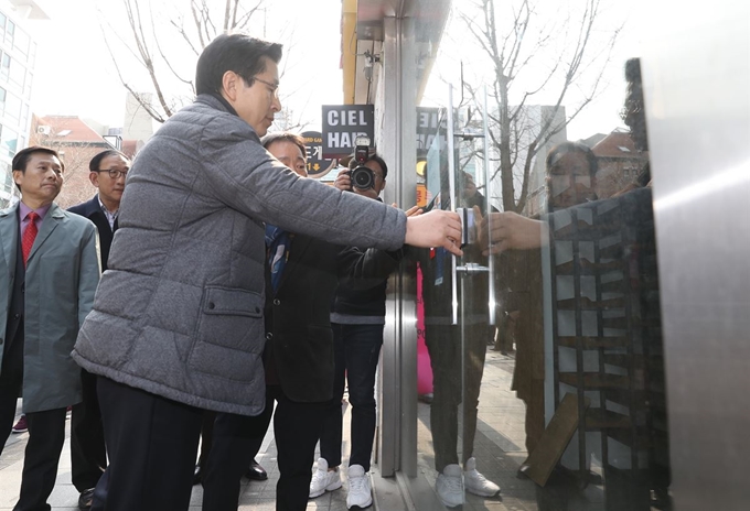 자유한국당 황교안 대표가 19일 오전 민생탐방 '국민과 함께'를 위해 찾은 서울 마포구 서교동 홍익대학교 삼거리에서 지역 상인협회 관계자로부터 경기가 어렵고 장사가 안된다는 설명을 들으며 비어있는 점포를 살펴보고 있다. 연합뉴스