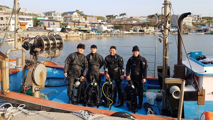 윤영규(60ㆍ오른쪽 끝)씨가 이끄는 한국생태연구원(주) 소속 전문 잠수부들이 경북 포항시 남구 구룡포읍 석병2리 앞바다에서 성게 등 바다 숲 조성에 방해되는 극피동물을 잡기 위해 입수하기 전 기념촬영을 하고 있다. 김정혜기자