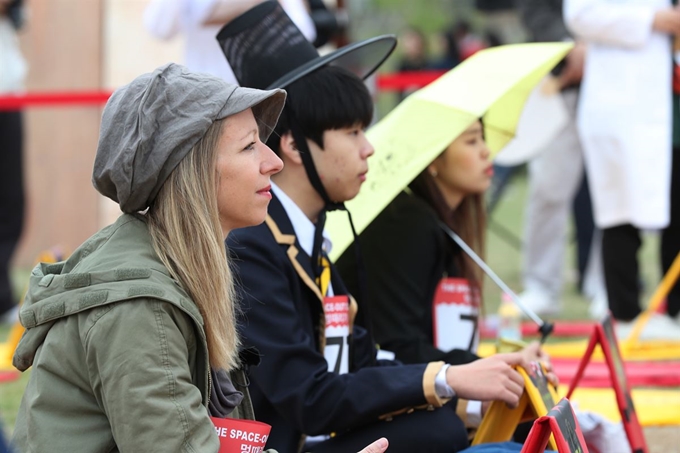 지난해 4월 서울 여의도한강공원에서 열린 ‘2018 한강 멍 때리기 대회’에서 참가자들이 가만히 앉아 허공을 응시하고 있다. 90분 동안 가장 안정적으로 멍 때리기에 성공한 참가자를 가리는 대회였다. 연합뉴스