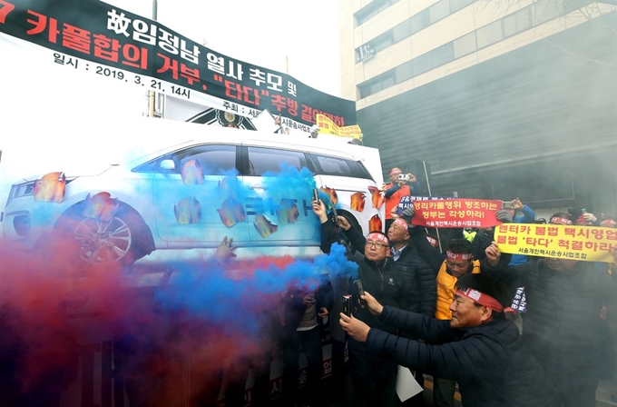 서울개인택시운송사업조합을 비롯한 택시단체 회원들이 21일 오후 서울 광화문광장 인근에서 열린 카풀(승차공유)합의 거부, '타다' 추방 결의대회'에서 승차공유 업체 '타다' 화형 퍼포먼스를 하고 있다. 뉴스1