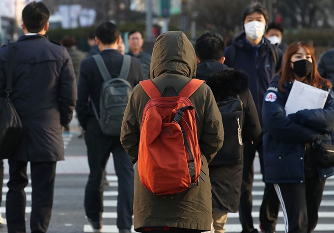 꽃샘추위가 찾아온 22일 서울 광화문네거리를 지나는 출근길 시민들이 두꺼운 옷차림을 하고 있다. 연합뉴스