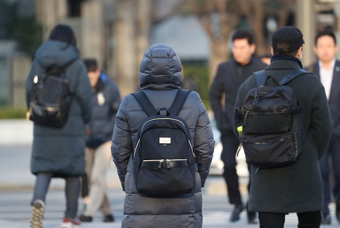 꽃샘추위가 찾아온 22일 서울 광화문네거리를 지나는 출근길 시민들이 두꺼운 옷차림을 하고 있다. 연합뉴스