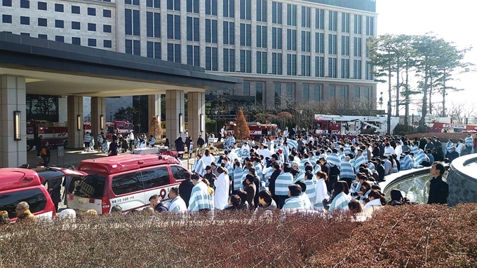 24일 오후 인천 중구 영종 파라다이스호텔 사우나에서 불이 난 가운데 대피한 투숙객들이 상황을 지켜보고 있다. 인천소방본부 제공