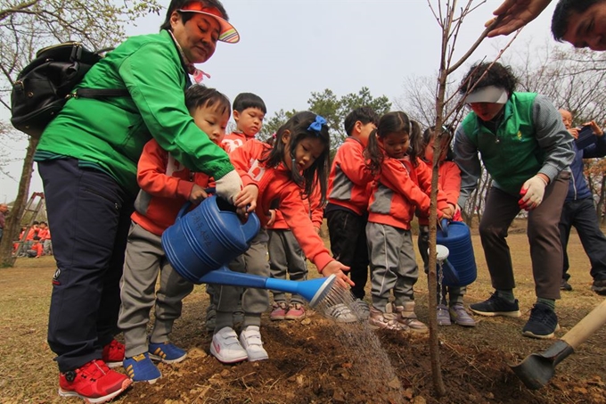 대구 달서구 공무원과 유치원 어린이들이 25일 달서구 도원공원에서 꽃복숭아 50그루, 이팝나무 55그루를 심고 있다. 김민규 기자 whitekmg@hankookilbo.com