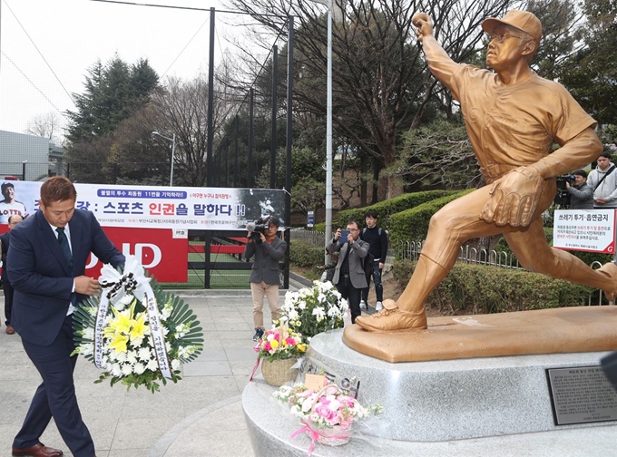 25일 부산 사직야구장 마당에 있는 고 최동원 선수 동상에서 이대호 프로야구선수협의회 회장이 헌화하고 있다. 연합뉴스