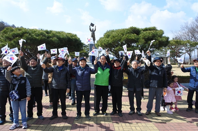 탐방객들이 유관순열사사적지 경내 동상 앞에서 만세삼창을 하고 있다.