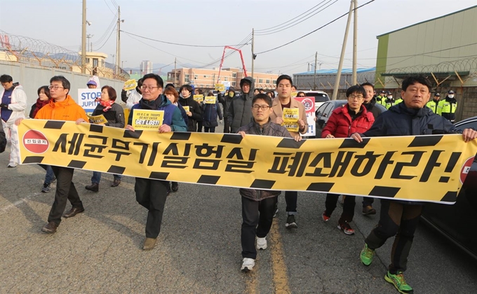 25일 부산 남구 감만동 8부두 앞에서 '미군 세균 무기 실험실 철거 남구주민대책위' 관계자들이 '주피터 프로그램 철폐'를 주장하며 출근하는 미군 차량을 가로막으려 하고 있다. 부산=연합뉴스