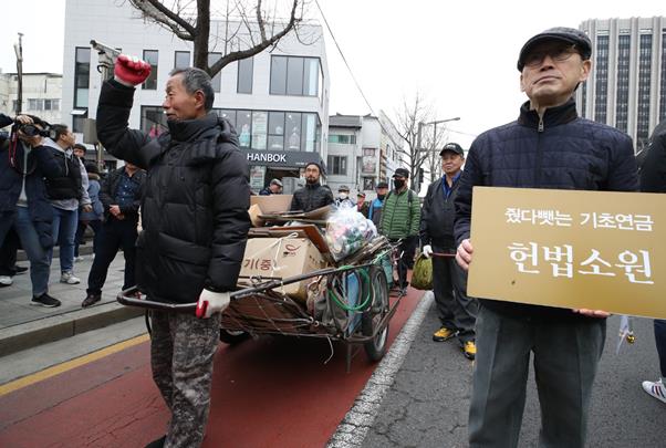 빈곤노인기초연금연대 회원과 노인들이 3월 25일 오전 서울 종로구 경복궁역에서 기초생활수급 노인들의 기초연금 박탈 문제 해결을 요구하며 청와대까지 행진하고 있다. 노인 소득기준 70% 이하인 노인에게 지급하는 기초연금은 소득불평등을 완화할 대표적 정책 수단이지만 그 범위를 놓고 다양한 주장이 맞서고 있다.