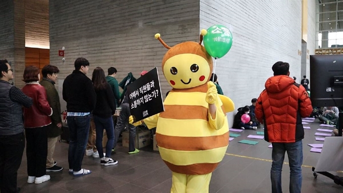 지난 2월20일 경기 성남 분당구에 있는 네이버 사옥 '그린팩토리' 1층 로비에서 열린 네이버 노조 공동성명의 집회 현장에서 마스코트인 꿀벌 탈을 쓴 네이비(NABEE)가 소통을 요구하는 초록색 풍선과 피켓을 들고 있다. 이날 조합원들은 초록색 후드티를 입고 풍선을 들고 야구 응원가나 동요 등을 불렀다. 민주노총 화학섬유식품산업노조 네이버지회 공동성명 제공