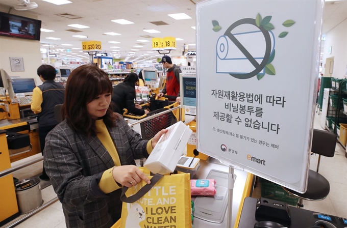 전국 대형마트, 백화점, 쇼핑몰 등지에서 일회용 비닐봉투 사용이 금지된 첫날인 1일 오전 서울 용산구의 한 대형마트의 계산대에 자원재활용법에 따라 비닐봉투를 제공하지 않는다는 안내문이 붙어 있다. 연합뉴스