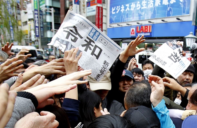 도쿄시내에서 일본의 새연호가 담긴 호외를 기념으로 간직하려는 사람들이 몰려들었다. 도쿄=AP 연합뉴스