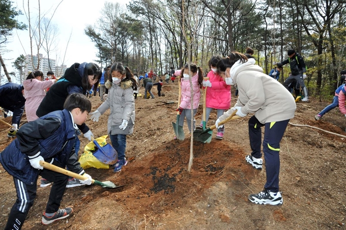 지난해 4월 7일 중앙공원에서 열린 제73회 식목일 기념 나무심기 행사 때 가족 등과 함께 나온 시민들이 나무를 심고 있다. 성남시 제공