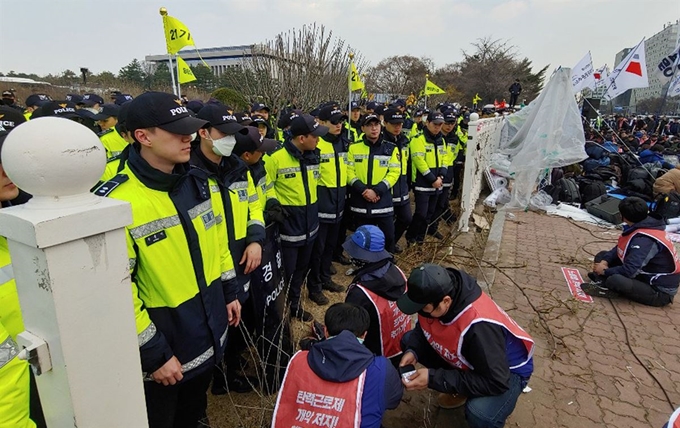 3일 오전 민주노총 조합원들이 국회 앞에서 노동법 개악 저지 등을 촉구하며 경내 진입을 시도하다 주 출입구 부근 담장이 무너졌다. 연합뉴스