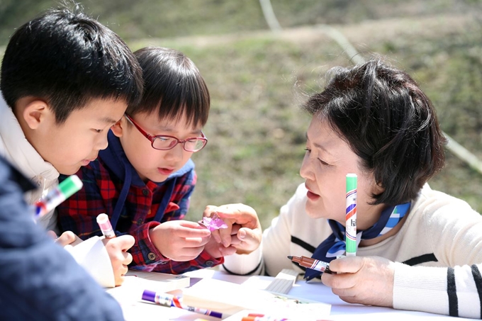 김정숙 여사가 식목일을 하루 앞둔 4일 오전 청와대 경내 유실수단지에서 청와대 인근 초등학교 어린이들을 초청해 함께 우리 꽃나무를 심은 뒤 팻말을 만들고 있다.청와대 제공