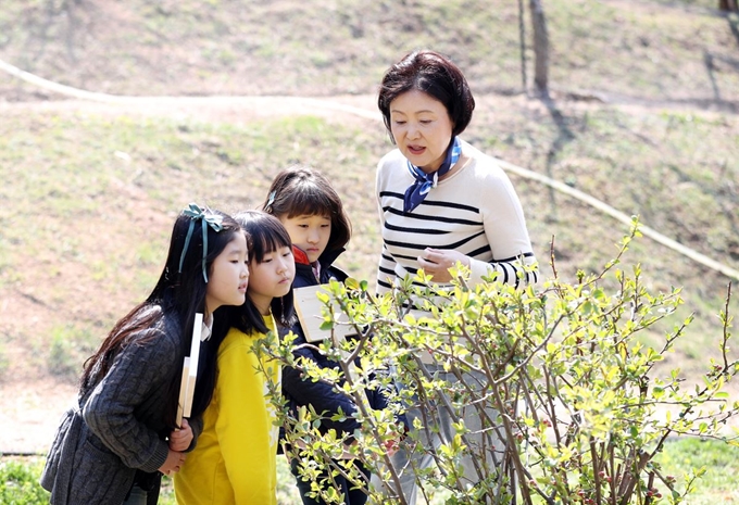 김정숙 여사가 식목일을 하루 앞둔 4일 오전 청와대 경내 유실수단지에서 청와대 인근 초등학교 어린이들을 초청해 함께 우리 꽃나무를 심기에 앞서 꽃나무 설명을 하고 있다.청와대 제공