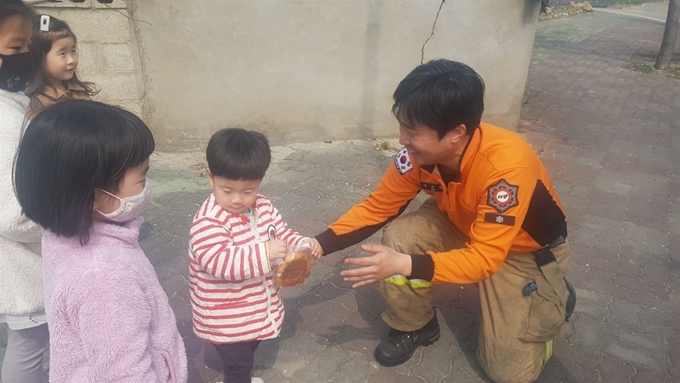 6일 오전 산불피해를 입은 강릉시 옥계면의 한 마을의 남녀 어린이 4명이 잔불정리 및 복구 작업에 투입된 강릉소방서 옥계119안전센터 소방관에게 과제를 건네며 감사한 마을을 전하는 순간이 포착돼 감동을 줬다. 이 소방관은 아이들에게 간식으로 지급된 땅을 건네며 감사의 마음을 전했다. 강원소방본부 제공