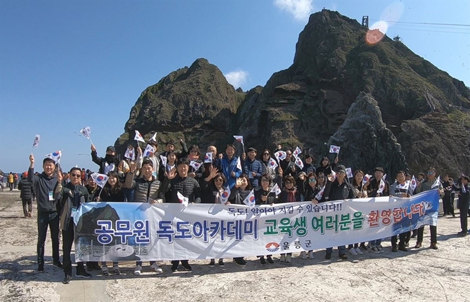 경북 울릉군이 전국 공무원을 대상으로 운영하는 독도아카데미의 299기 및 300기 수강을 신청한 공무원들이 3일 독도를 방문해 선착장에서 태극기를 흔들며 기념촬영을 하고 있다. 울릉군 제공