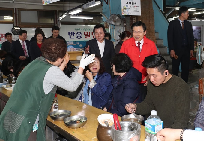 황교안 자유한국당 대표와 강기윤 전 4ㆍ3 보궐선거 후보가 8일 오후 경남 창원시 반송시장에서 상인의 박수를 받으며 미소를 짓고 있다. 뉴스1