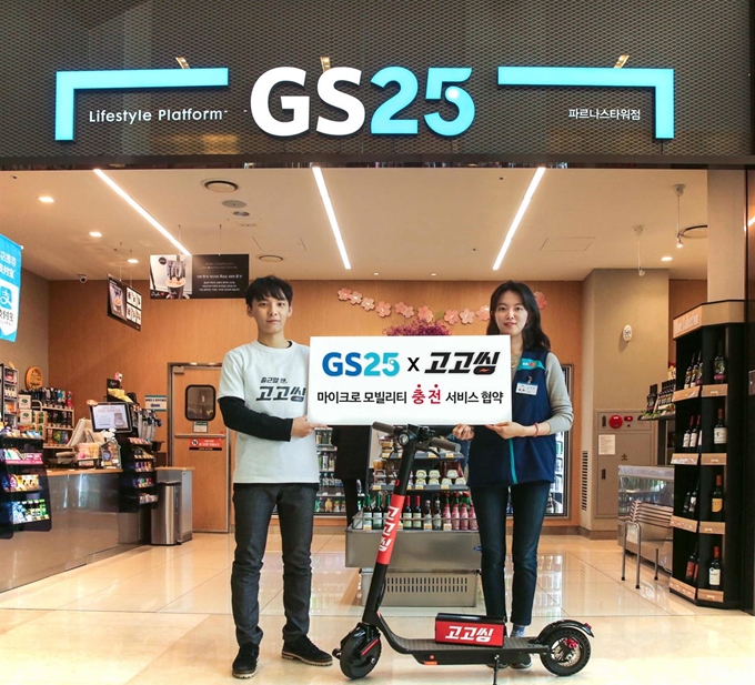 GS25 점포 앞에서 GS25직원(오른쪽)과 고고씽 직원이 마이크로모빌리티 충전서비스 홍보를 하는 모습. GS25 제공