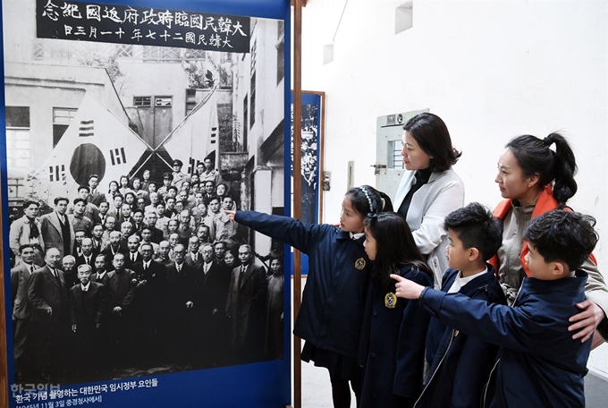 대한민국 임시정부 수립 100주년인 11일 오후 서울 서대문역사기념관을 찾은 경기초등학교 학생들이 어머니와 함께 옛 서대문 형무소 내에 전시된 임정요인들의 중국 충칭 임정청사 앞 환국 기념사진 속에서 김구 주석을 찾고 있다.고영권 기자