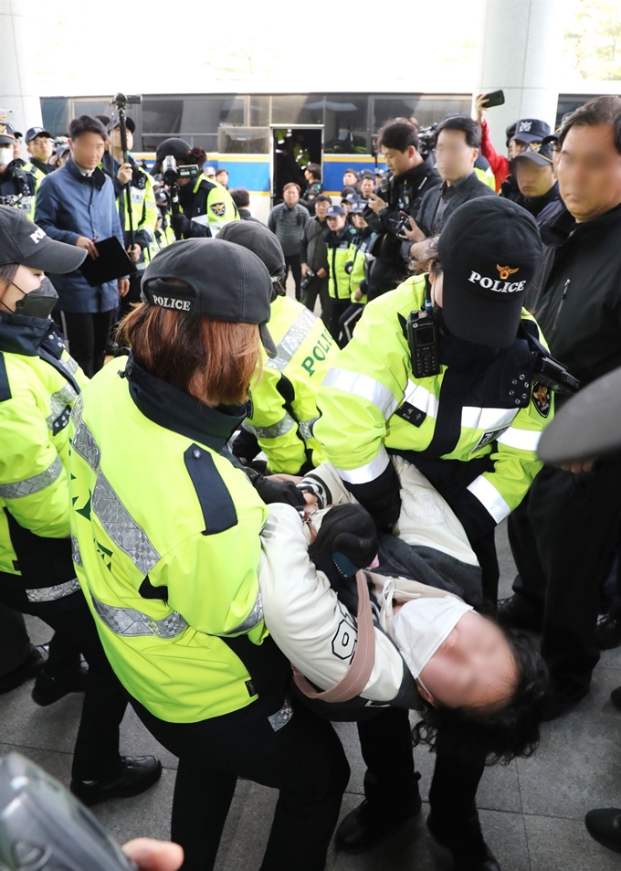 12일 오전 자유한국당 나경원 원내대표의 국회 의원회관 사무실을 기습 점거했던 한국대학생진보연합 학생들이 회관 본청 현관 앞에서 농성을 이어가다 경찰에 연행되고 있다. 연합뉴스