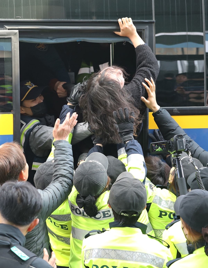 12일 오전 자유한국당 나경원 원내대표의 국회 의원회관 사무실을 기습 점거했던 한국대학생진보연합 학생들이 회관 본청 현관 앞에서 농성을 이어가다 경찰에 연행되고 있다. 연합뉴스