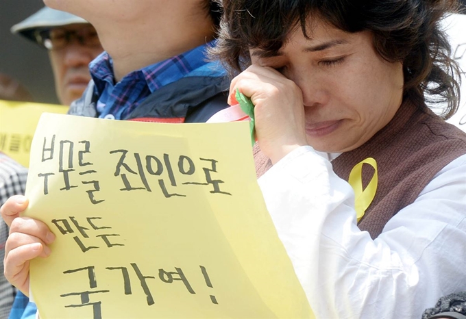 참교육을 위한 전국학부모회가 8일 오후 서울 종로구 세종로 광화문광장에서 진행한 '세월호 참사 진상규명 및 책임자 처벌을 촉구하는 전국학부모 기자회견' 중 한 참가자가 눈물을 흘리고 있다. 뉴시스