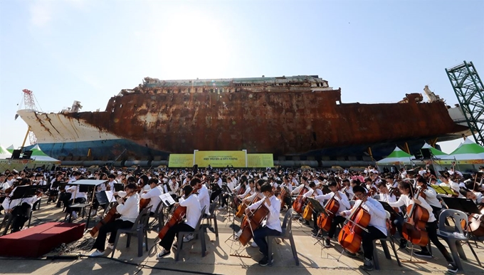 세월호 5주기를 며칠 앞둔 지난 12일 오후 전남 목포신항에 거치된 세월호 앞에서 전남 20개 시군의 드림오케스트라 1,000명 어린이 단원이 4·16합창단과 함께 추모음악회를 개최하고 있다. 목포=연합뉴스