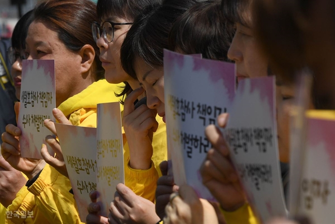 세월호 참사 5주기를 하루 앞둔 15일 서울 세종대로 광화문광장에서 열린 '세월호 참사 책임자 처벌 대상 1차 발표 기자회견'에서 4·16세월호참사가족협의회 관계자들이 '특별수사단 설치 책임자 처벌' 팻말을 들고 눈물을 닦고 있다. 서재훈 기자