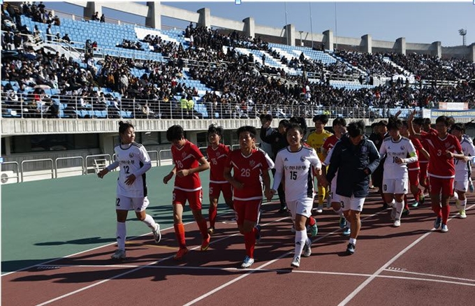 지난해 10월 열린 제5회 아리스포츠컵유소년축구대회에 앞서 한국과 북한 여자축구팀 선수들이 친선경기 후 손을 맞잡고 트랙을 돌고 있다. 고양시 제공