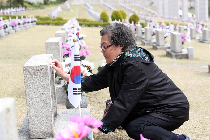 4·19혁명 59주년을 하루 앞두 18일 오전 서울 강북구 국립4·19민주묘지에서 이명자씨가 남동생 이기석씨의 묘비를 닦아주고 있다. 연합뉴스